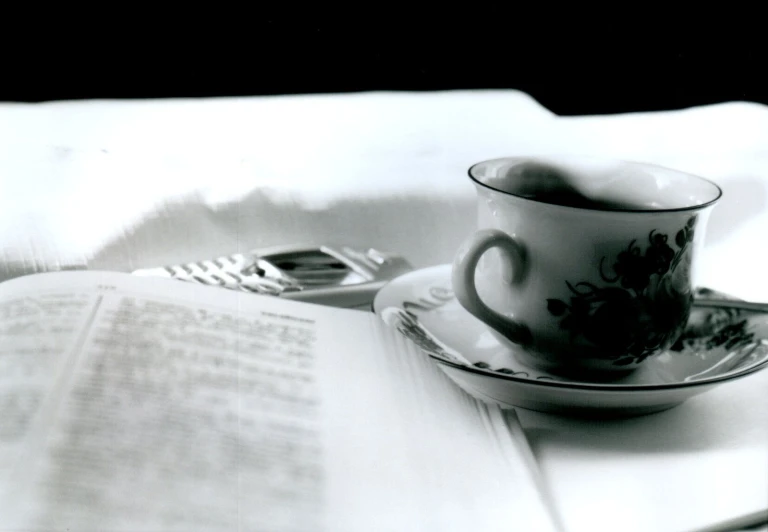 an open book and teacup on a plate