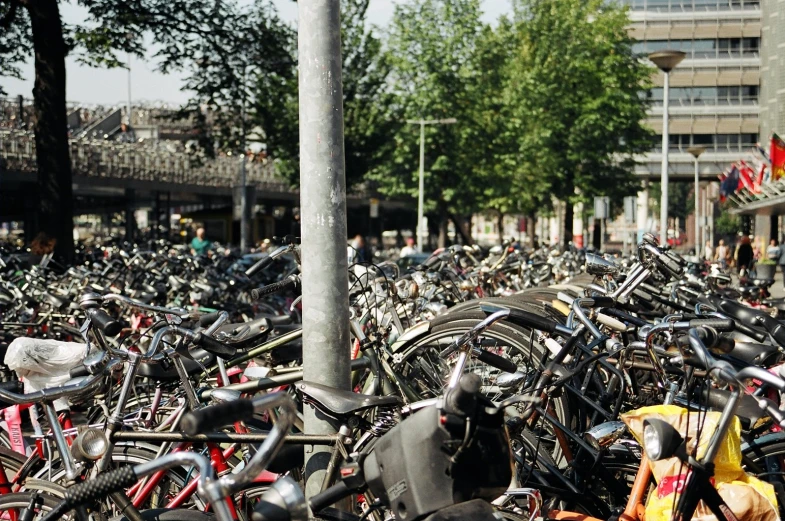 a pile of bicycles sitting in a large parking lot