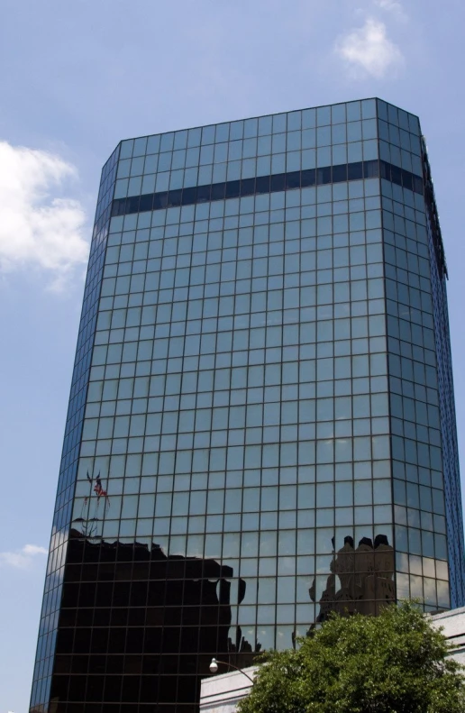 a tall black building sitting next to a tree