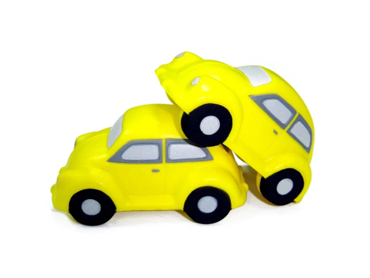 two yellow toy cars are in the shape of a car