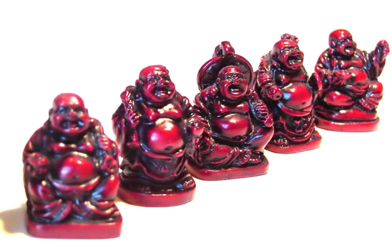 five buddha figurines sit in line in a row