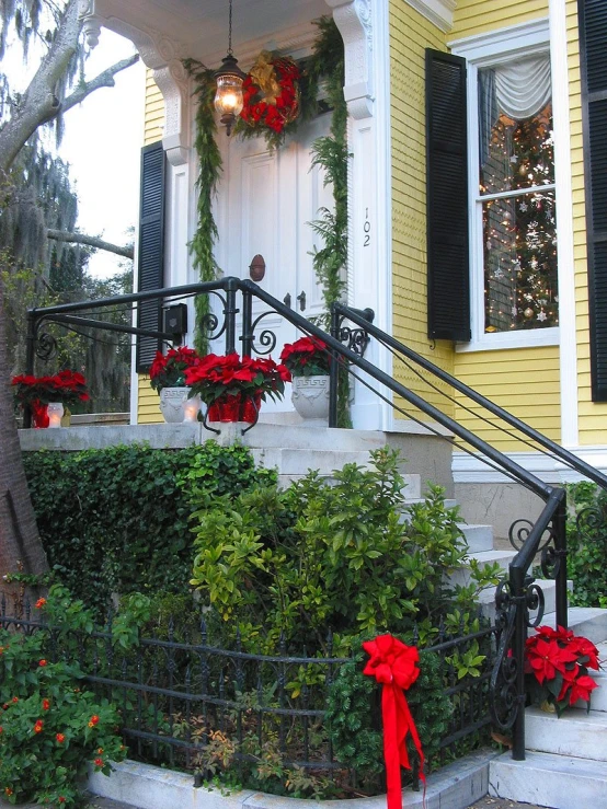 a yellow house is decorated with red and white flowers