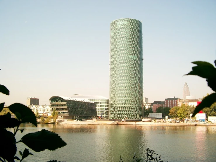 a tall building sits next to a river