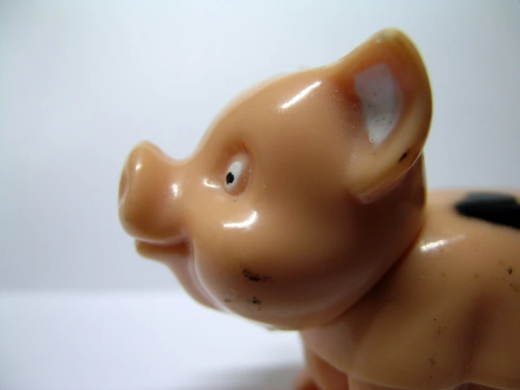 a plastic elephant that is brown and has black patches on the front of its face