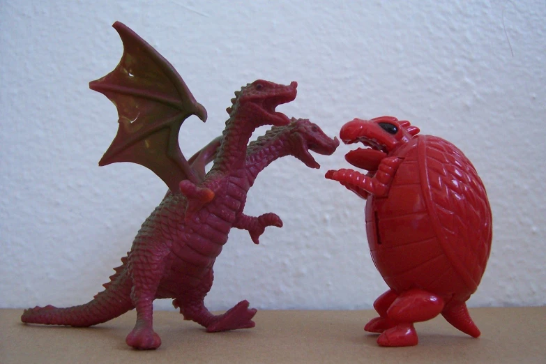 there is a red dragon facing a smaller one