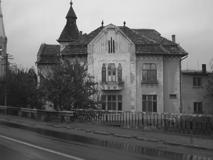 an old house is on the side of a road