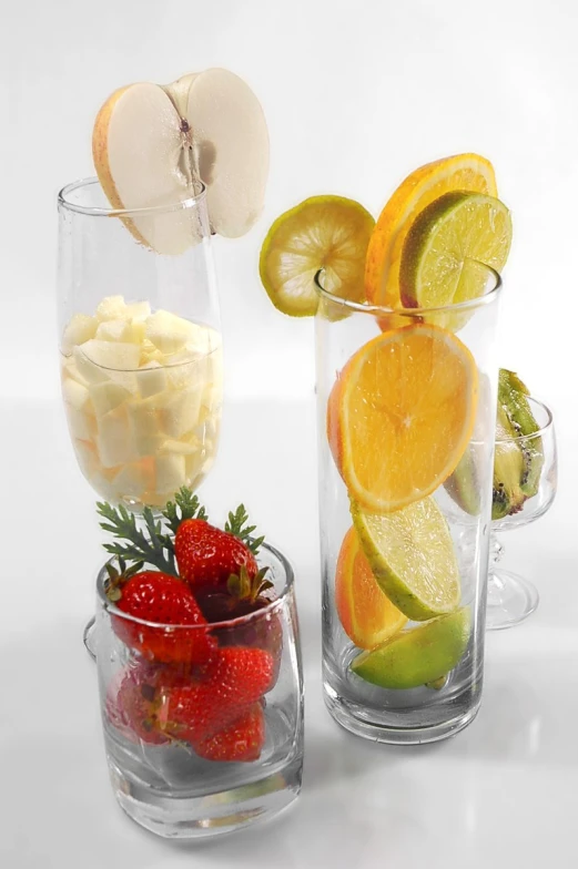 a group of fruits and bowls inside of glass vases