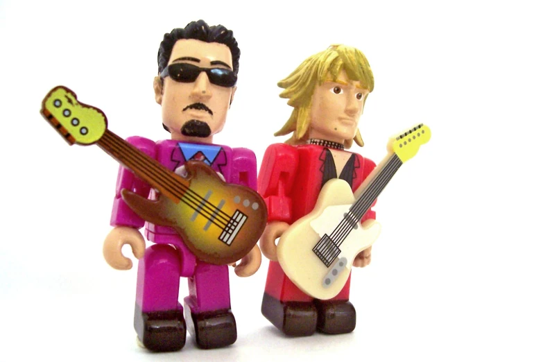 two plastic figures of men holding guitars and guitar