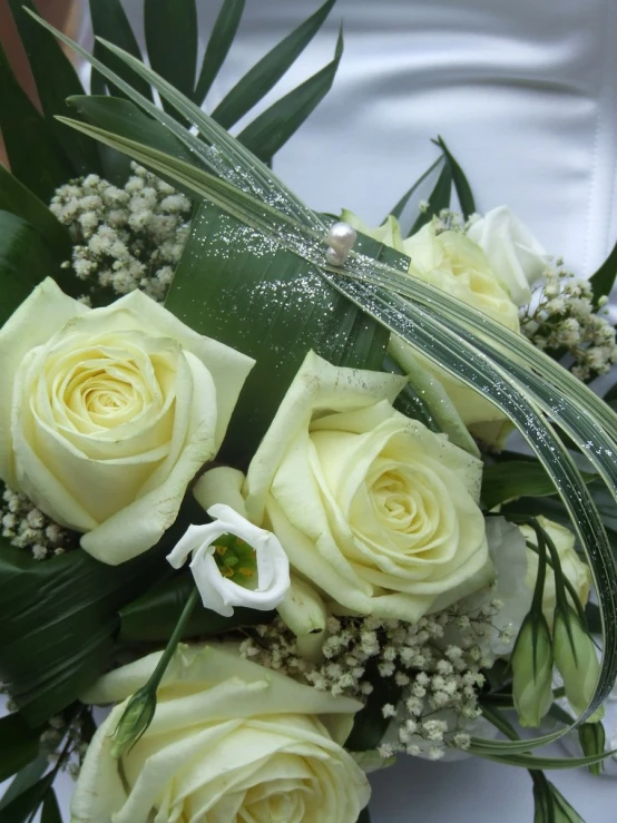 a bride's bouquet of white roses and greenery