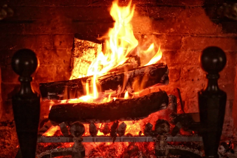 fire blazing in fireplace with no mantle and wood