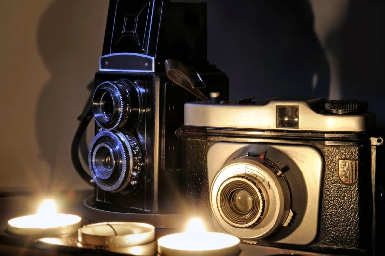 a small camera and candles on top of a table