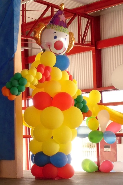 a clown balloon hanging from the ceiling in a building