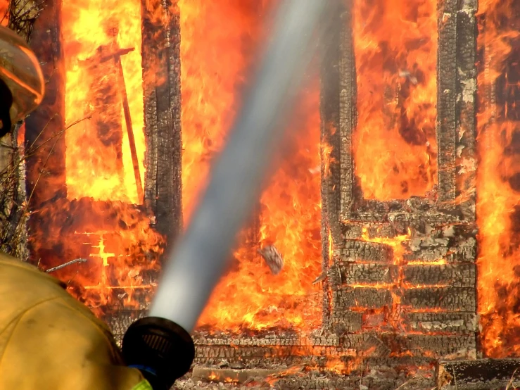 two fire fighters in front of a huge fire