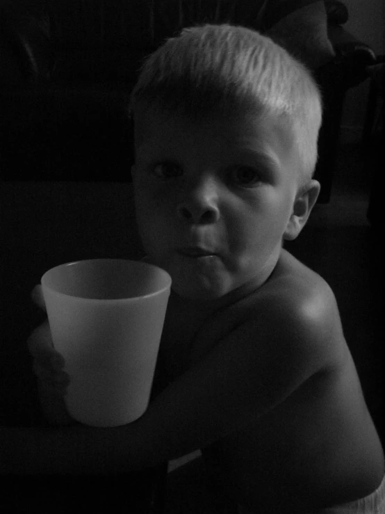 a  holding a cup in the dark with their nose