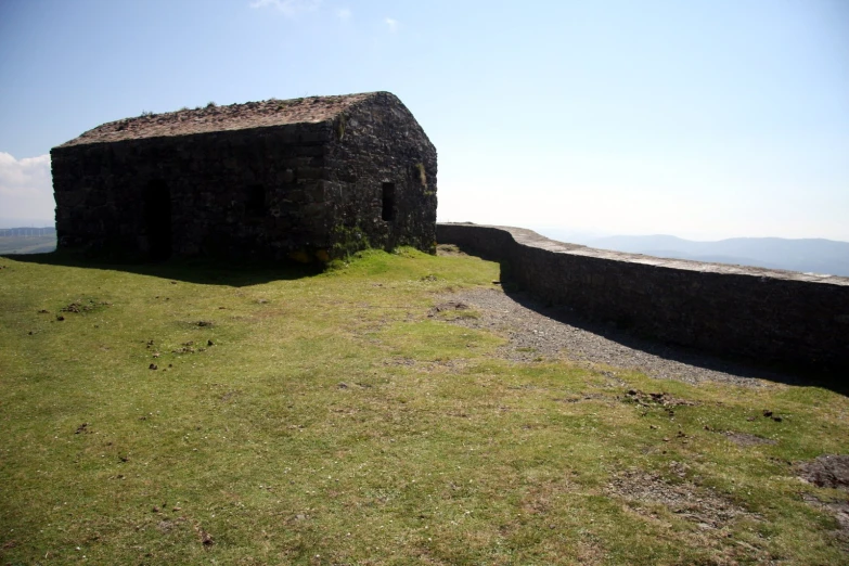 a lone rock wall and the side of an old building