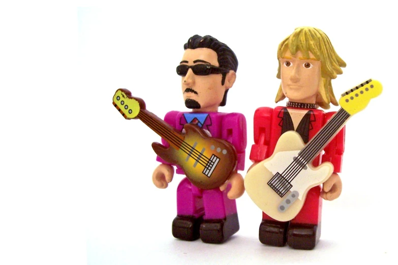 a couple of toy figurines that are holding guitars