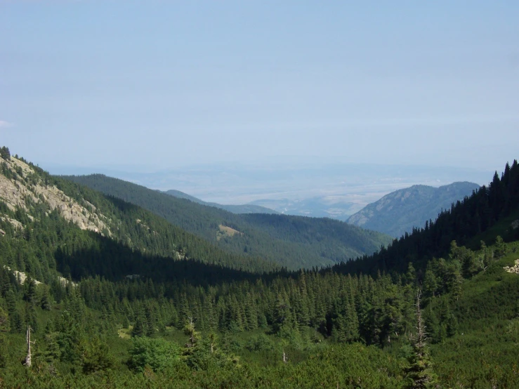 a beautiful mountain is shown surrounded by the green hills