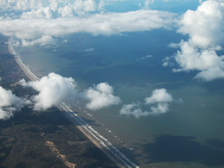 some white clouds and green water below it