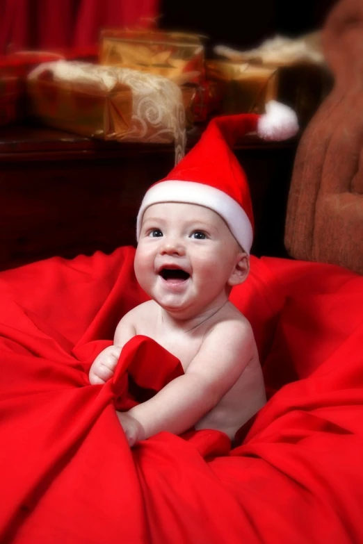 a baby wearing a christmas hat with red ribbon around it