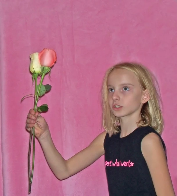 a  holding a pink rose with red and yellow centers