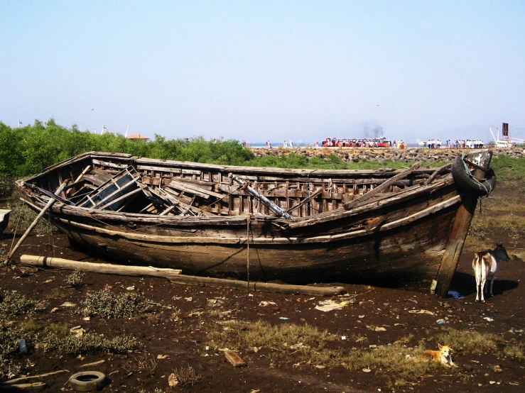 an old boat sitting out in a muddy field