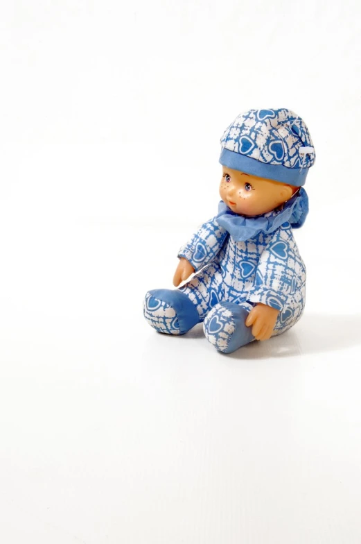 a blue and white doll on a white background