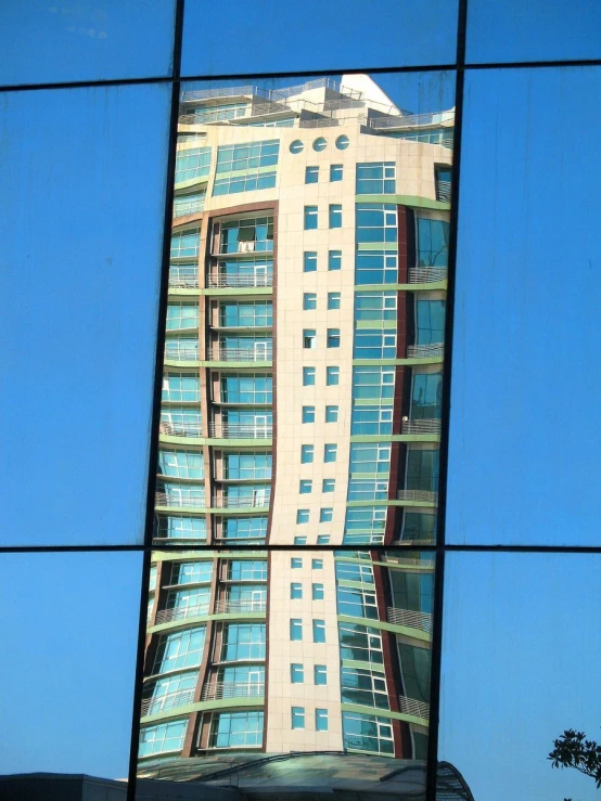 the reflection of a large building in a mirror