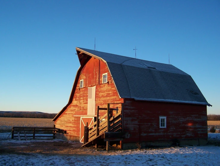 there is a red barn in the snowy field