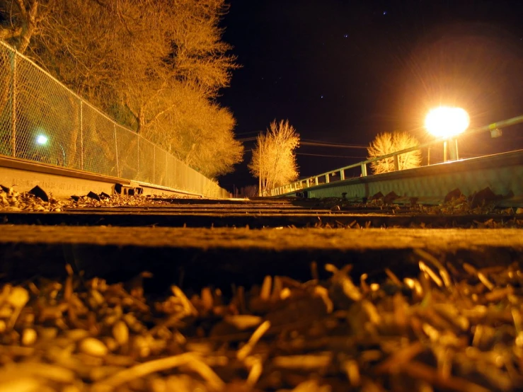 a train track by a fence at night