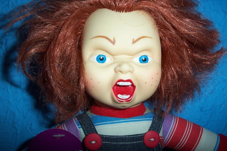 a dolls head with red hair has blue eyes and tongue