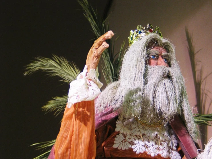 an old man dressed in costume is pointing at soing