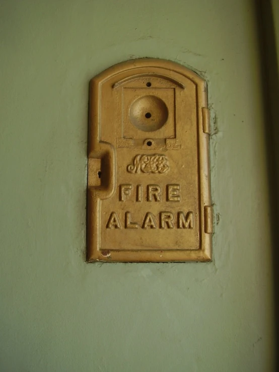 a door to a building with an old fire alarm