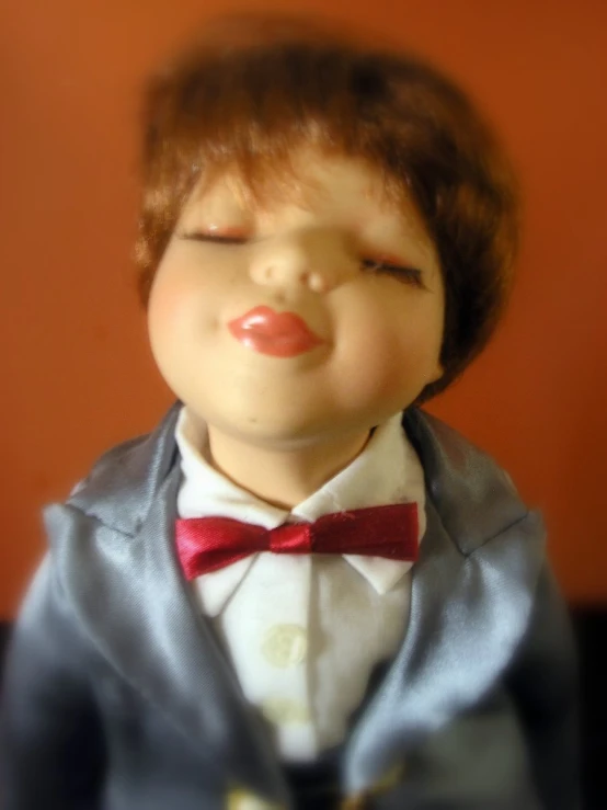 a close up of an old fashioned boy doll