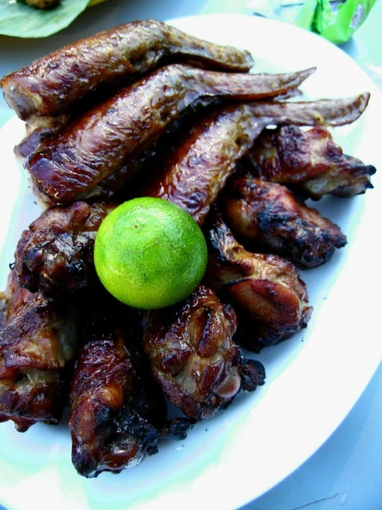 a plate of food with meat and a green ball