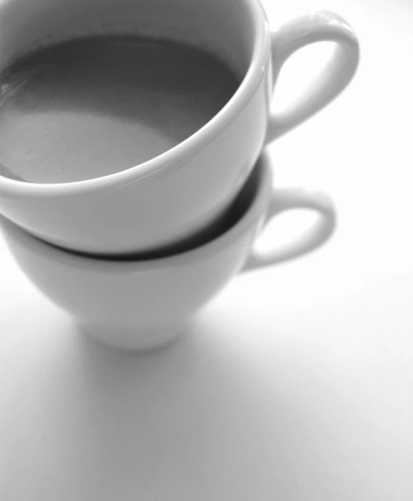 the two mugs are placed together to be filled with different types of beverage