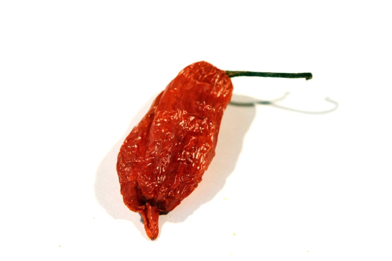 a long  chili sitting on top of a white table
