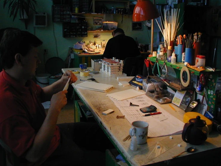 two men are making crafts at the craft studio