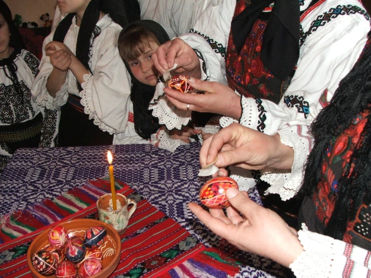 people dressed in ethnic clothing and holding up their food