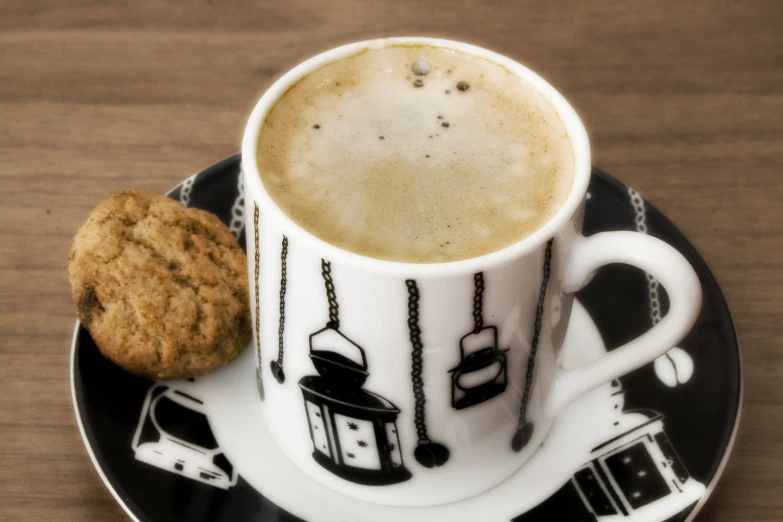 a cookie is next to a cup of coffee