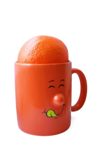 a red ceramic mug with a smile and a orange inside it