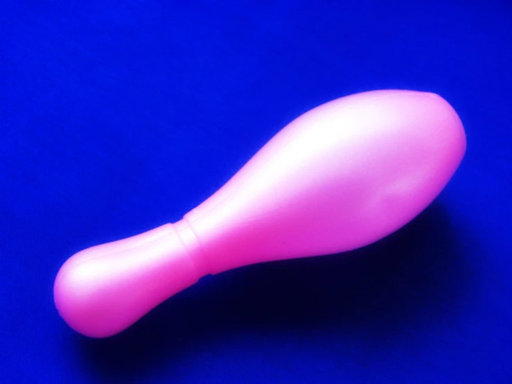 a plastic pink object on a blue surface