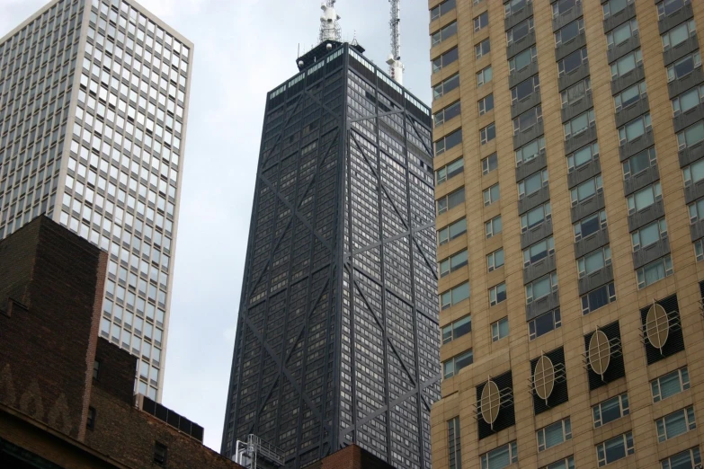 three very tall buildings in a city with a tower