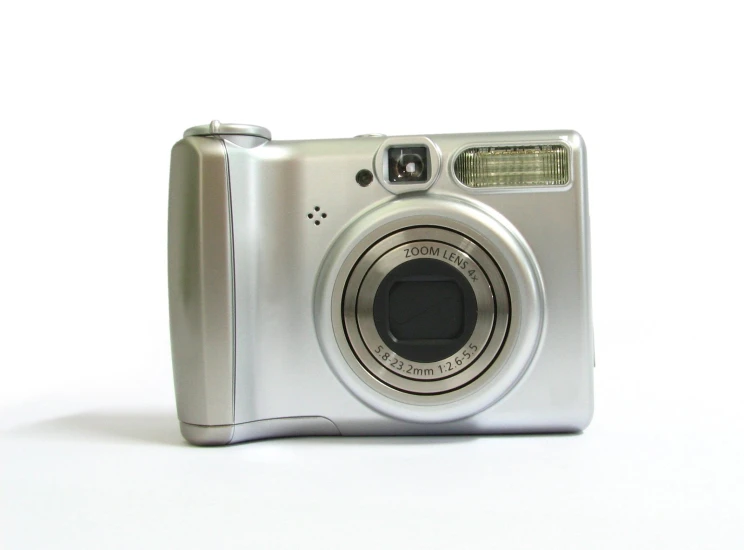 a silver camera on a white surface