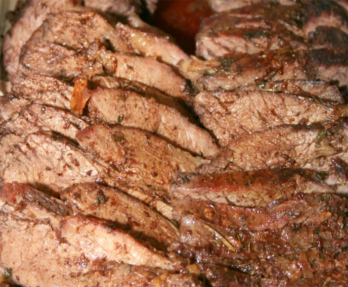 some meat is cut up and stacked on a plate