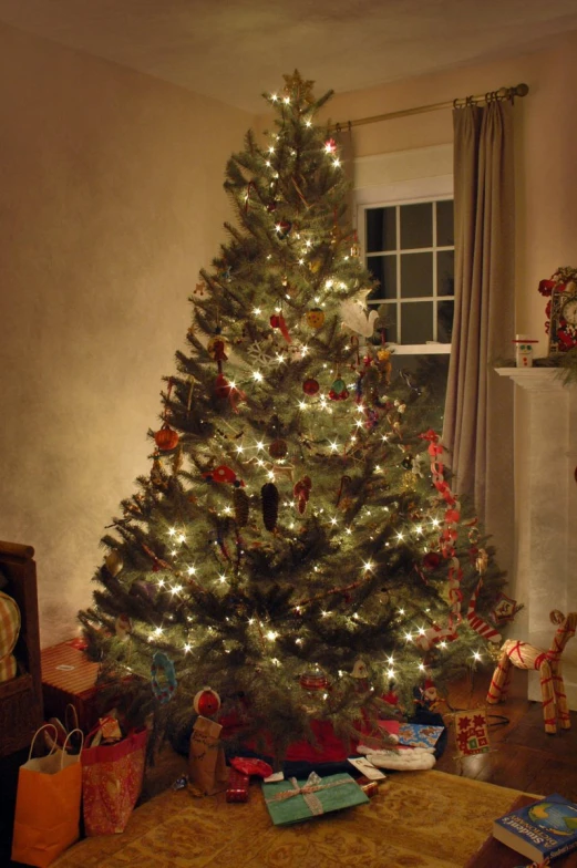 a christmas tree with lights, presents and gifts