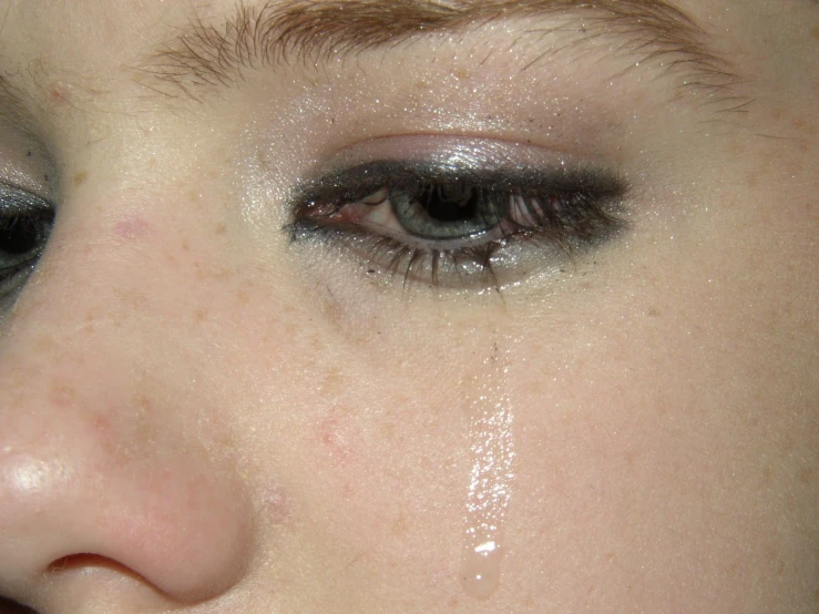a woman with dark make - up and a gray eyeshade