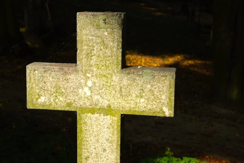 a stone cross that looks like the remains of a grave