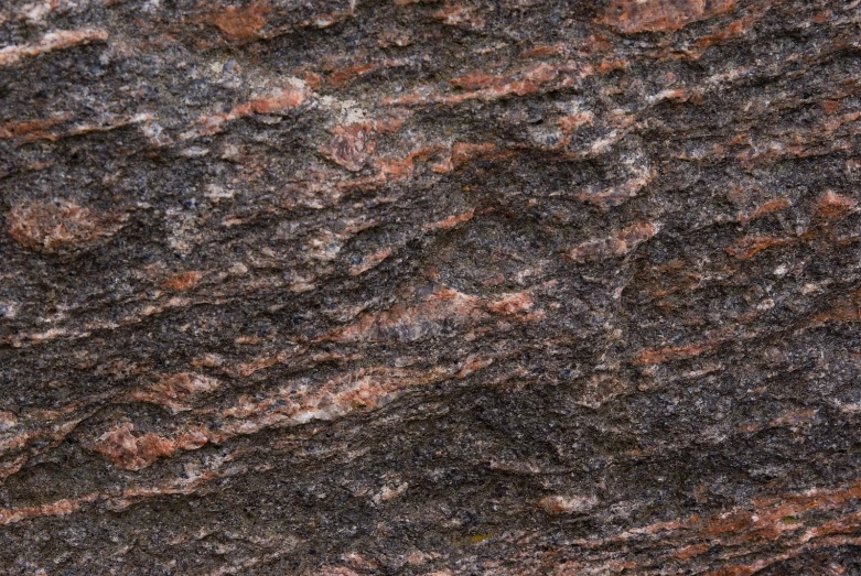 black and brown rocks textured together with red lichen