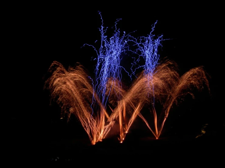 a firework display with purple and blue flames