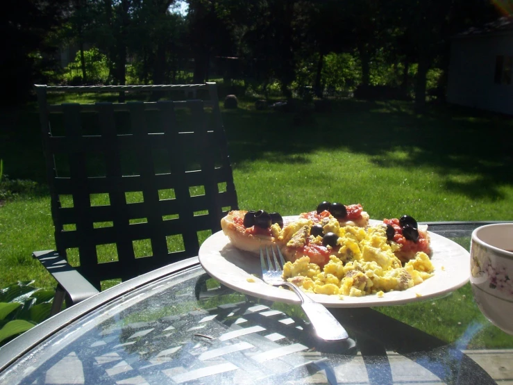 a plate of food sitting on a glass table outside